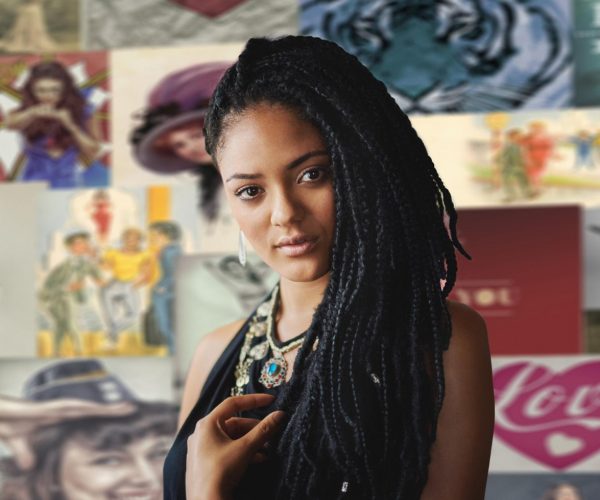 Uma mulher preta jovem com longas tranças, vestindo uma blusa escura e um colar com um pingente azul, aparece em destaque. Ao fundo, há uma colagem de imagens de estilo vintage, com ilustrações de mulheres e outras figuras em poses variadas. A expressão da mulher é serena e confiante, enquanto o ambiente ao redor evoca uma estética artística e cultural. A imagem transmite um sentimento de diversidade e autenticidade, destacando o tema de cultura e impacto social ao sugerir a conexão entre a identidade visual e o contexto histórico e social representado nas obras ao fundo.